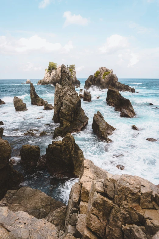 some rocky rocks a body of water and some clouds