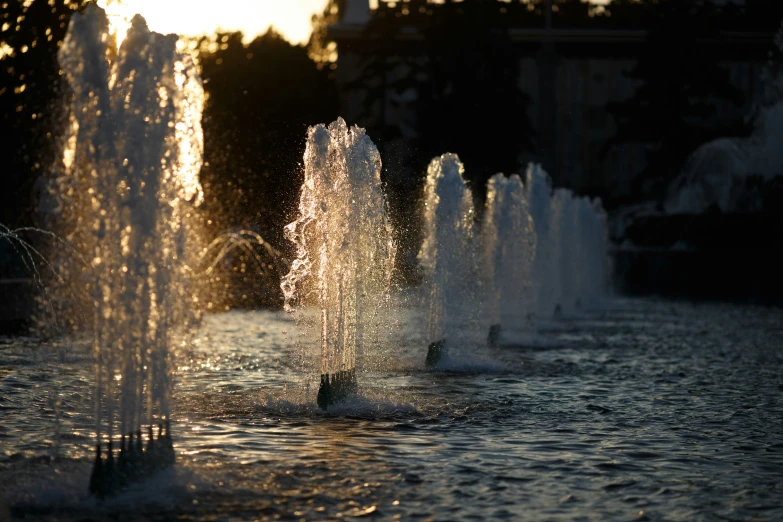 water is shooting up from three fountains on the lake