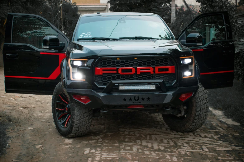 two very nice looking black trucks in the dirt