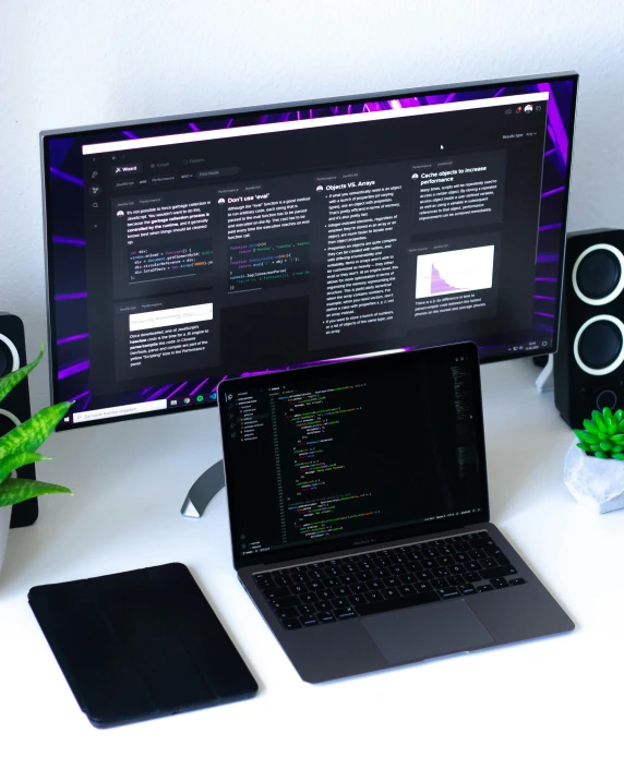 a white desk with a laptop and monitor on it