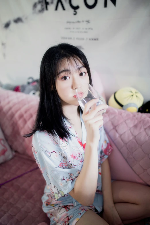 a young asian woman drinking from a glass