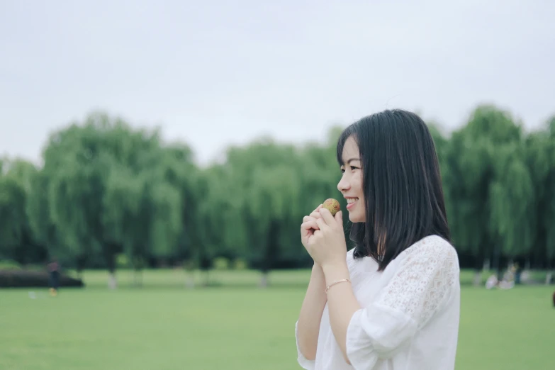 woman holding onto a green apple in her hand