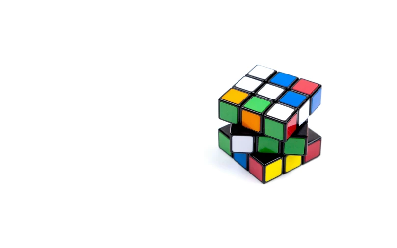 a rubik cube sitting upright against a white background