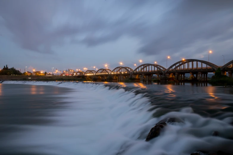 an empty river is flowing under the bridge