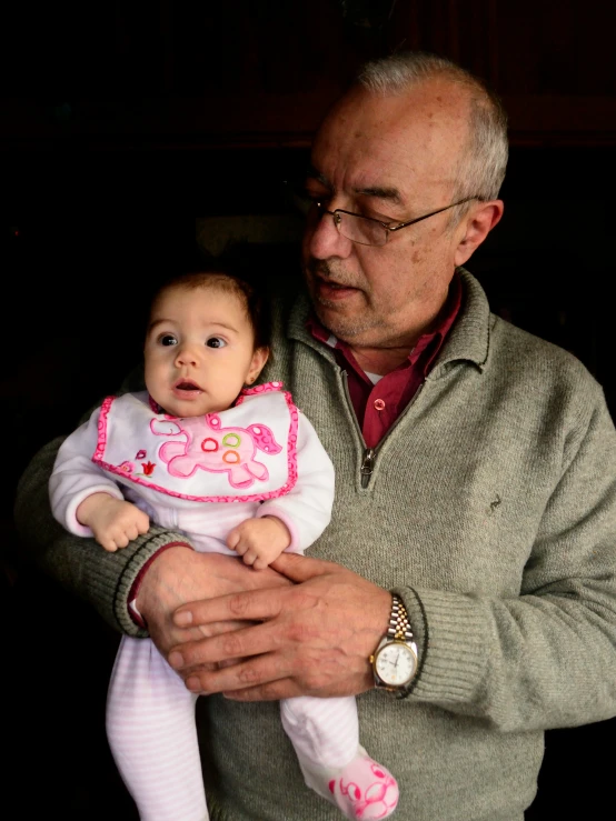 a man holds his baby in his arms