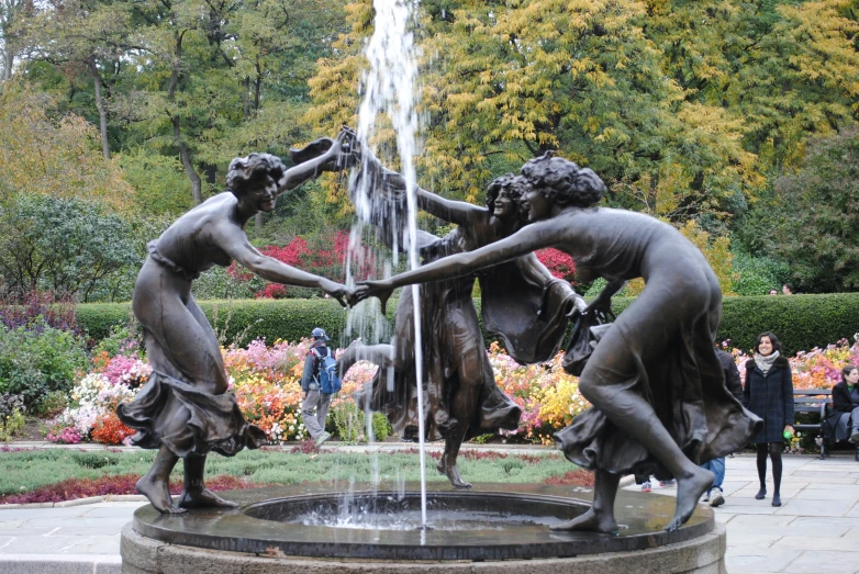 a fountain with four girls playing in the fountain
