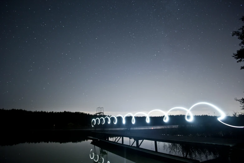 long exposure pograph of light painting on bridge over water