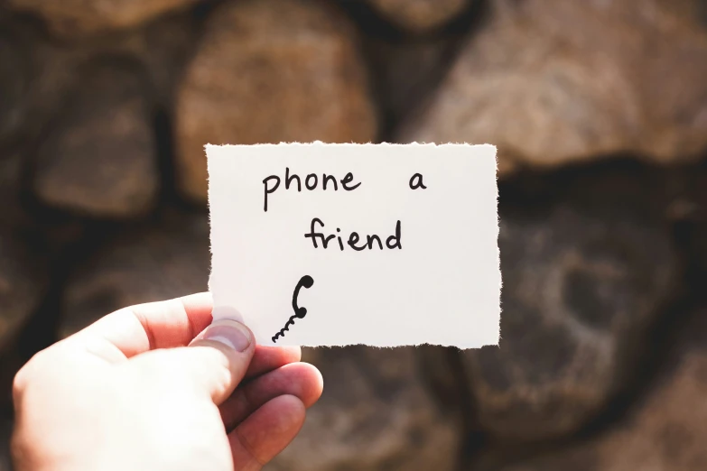 someone holding a note that reads phone a friend