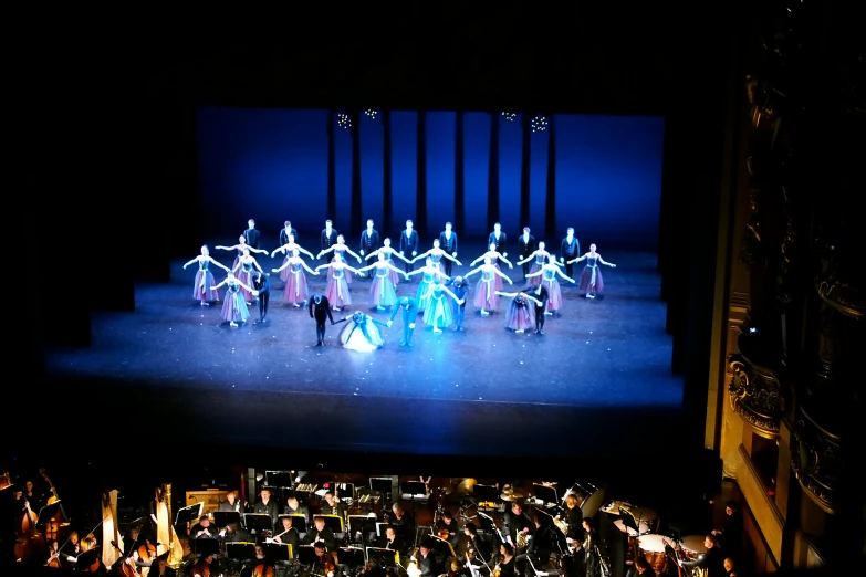 many people are performing a dance with different colored lights