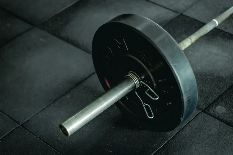 a gym bar sitting on top of a tiled floor