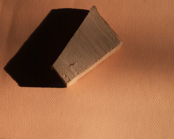 wooden block sitting in the middle of an orange and beige cloth