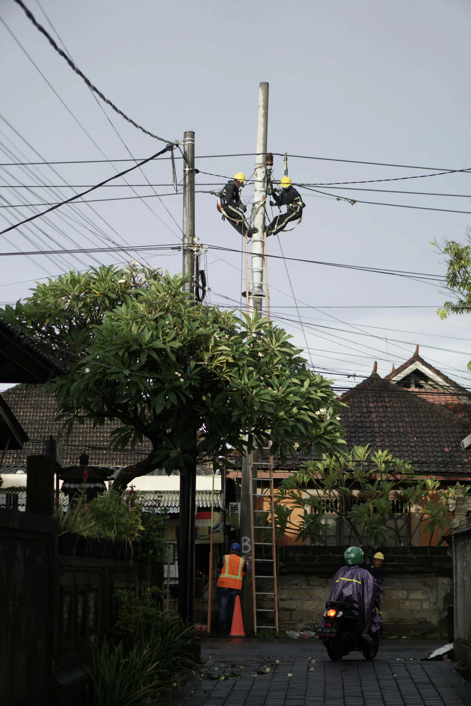 two men working on electrical equipment in front of a house