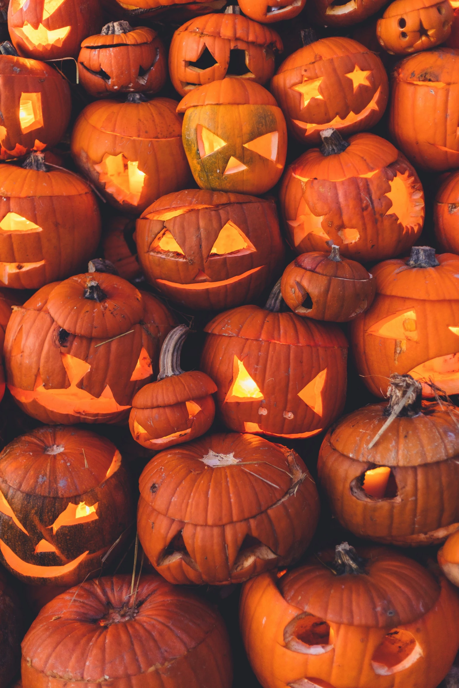 a bunch of pumpkins with carved faces and eyes