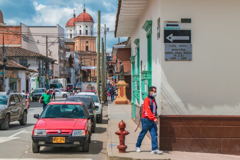 a man walking along the side of the road near a city street