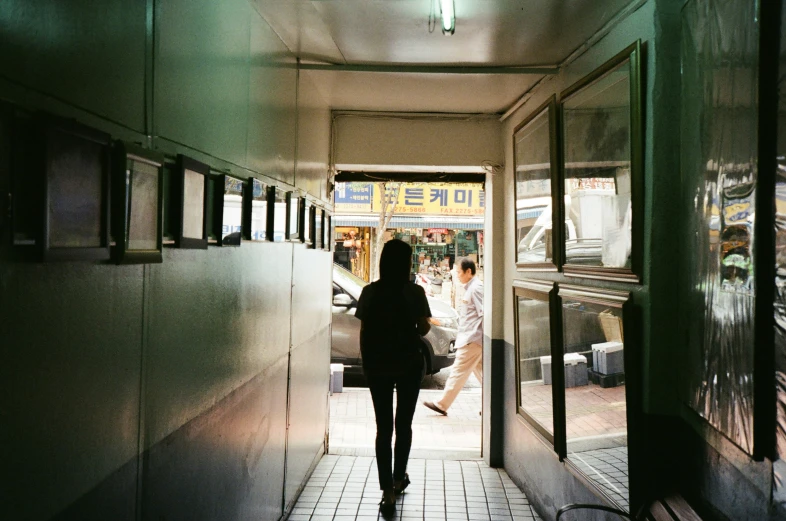 a woman walking into a train car tunnel next to another woman