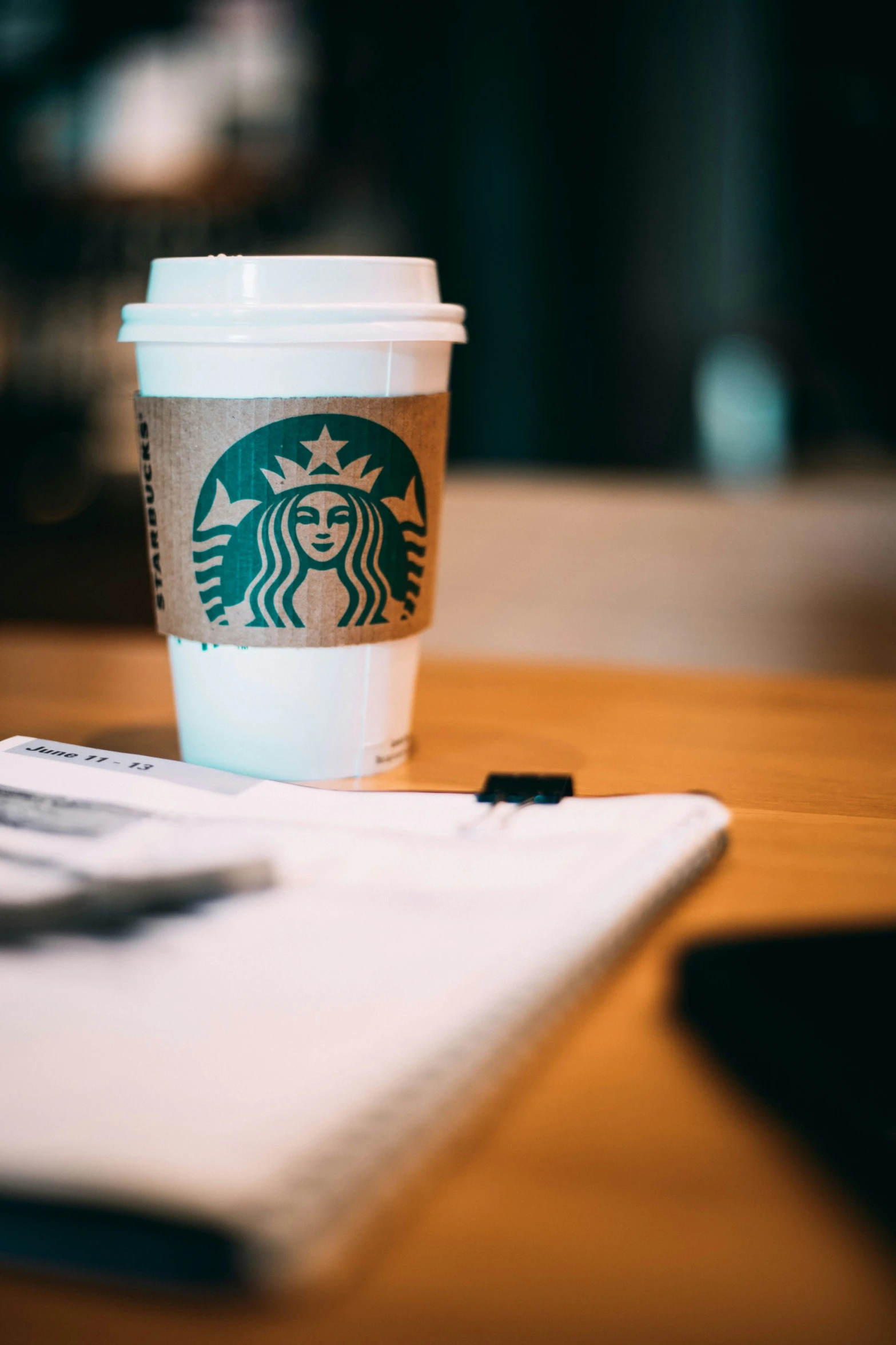 a coffee cup on a desk next to some pad