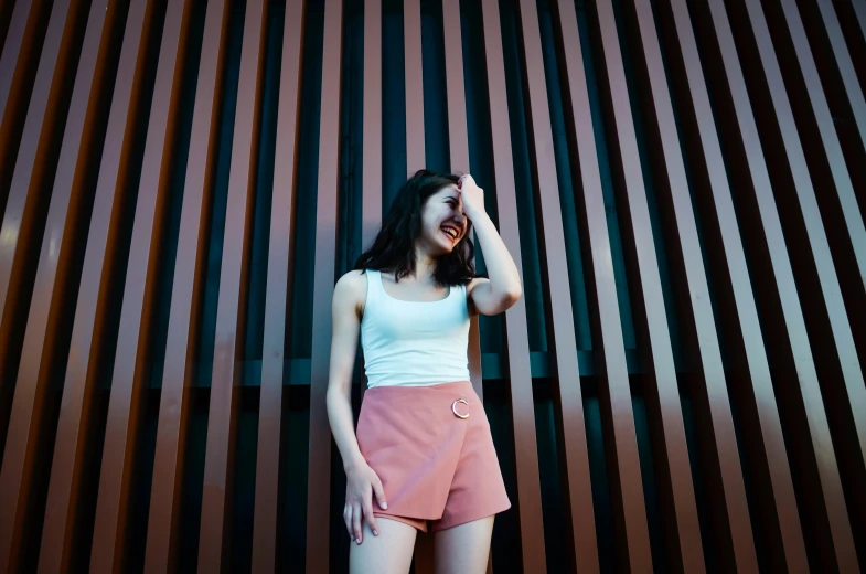 a girl smiling while standing in front of a metal wall