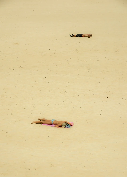 a couple lying on a beach in their bikinis