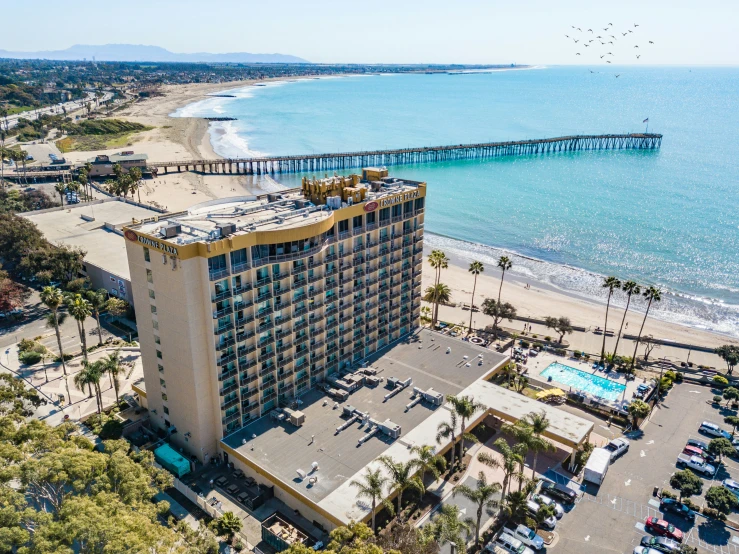 an aerial view of an ocean front resort, els and cars