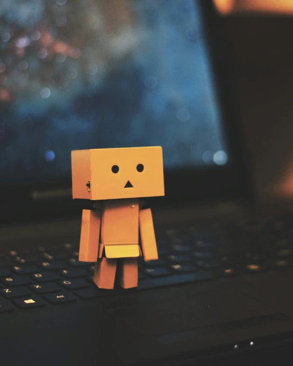 small, stylized figure placed on laptop keyboard