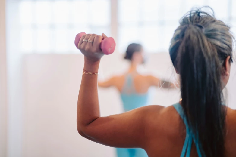 woman exercising with two weights in a gym