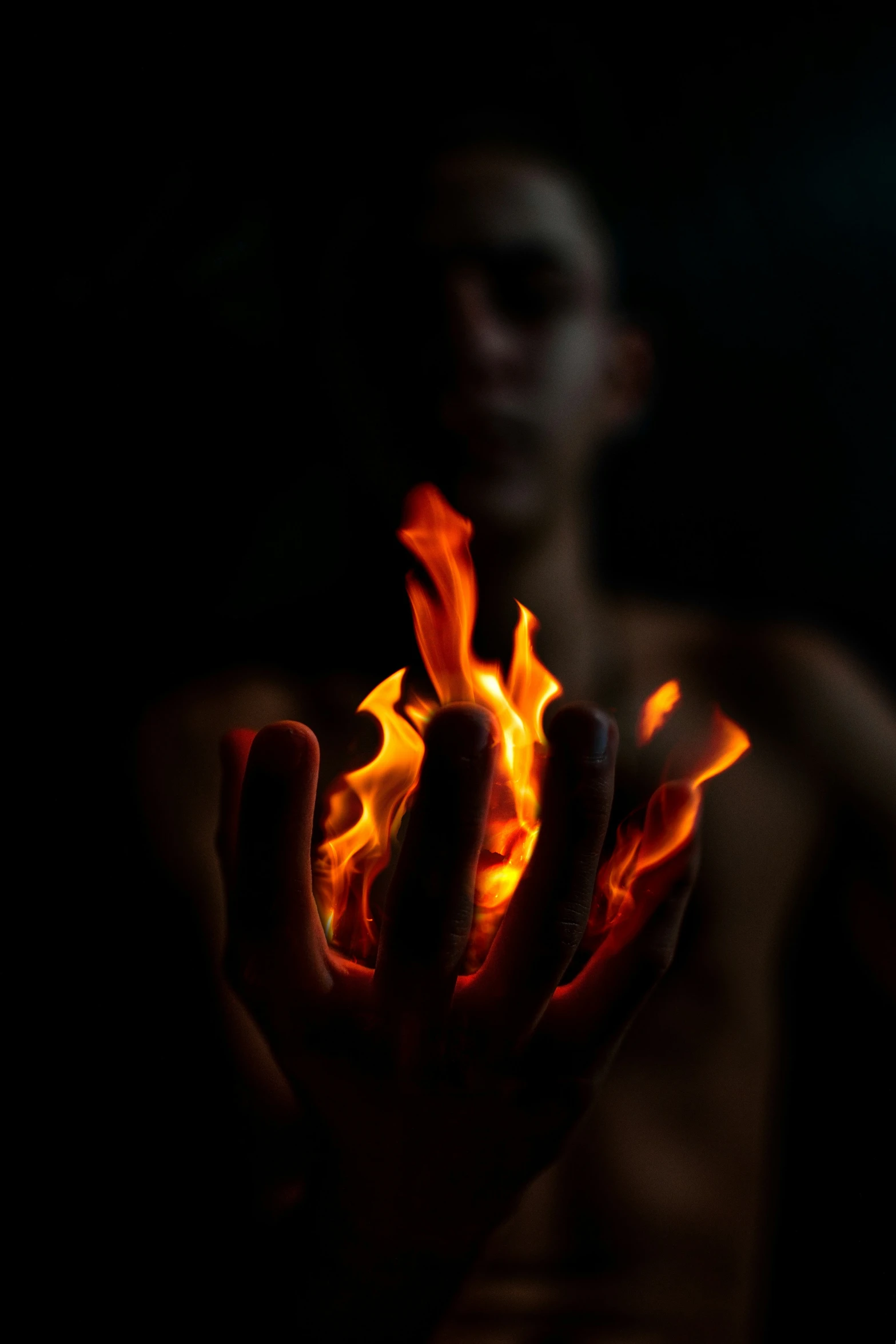 a man holding up fire and flames