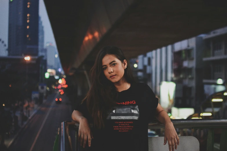 woman leaning on railing in city at night