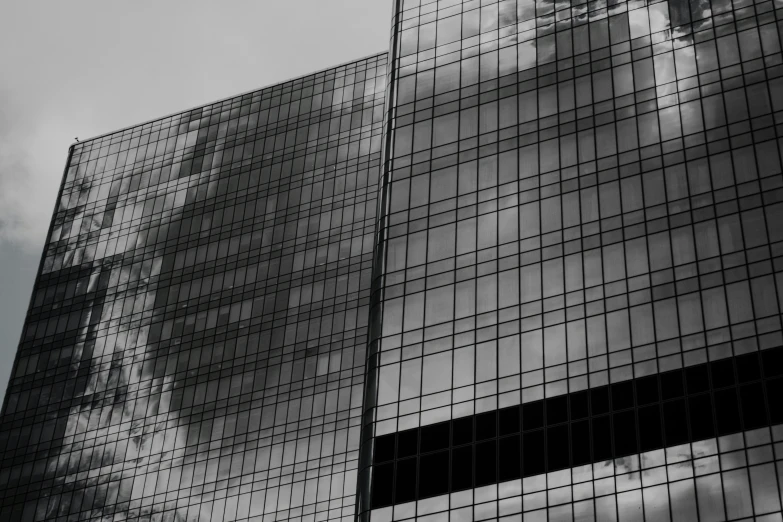 a tall building with glass windows near another tower