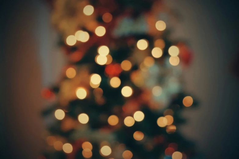 blurry lit christmas tree with a star and snow