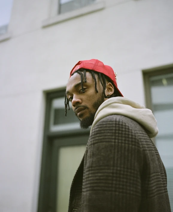 a man with dreadlocks looks into the distance