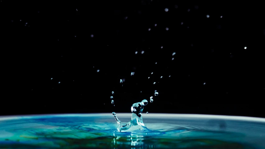 a water fountain is in the dark and blue liquid