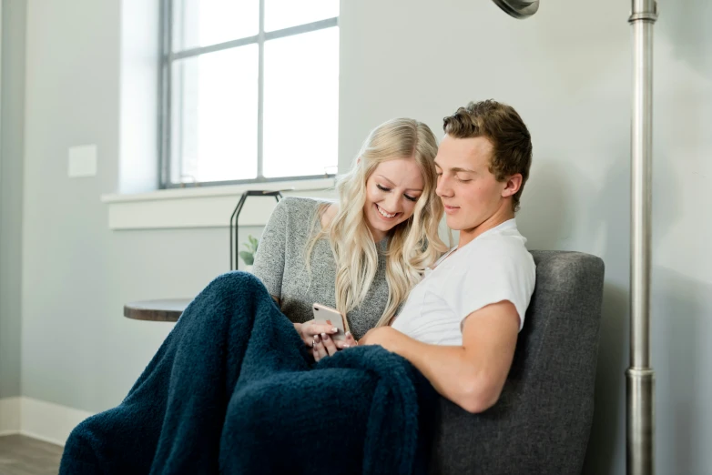 a couple cuddling on a couch in a home