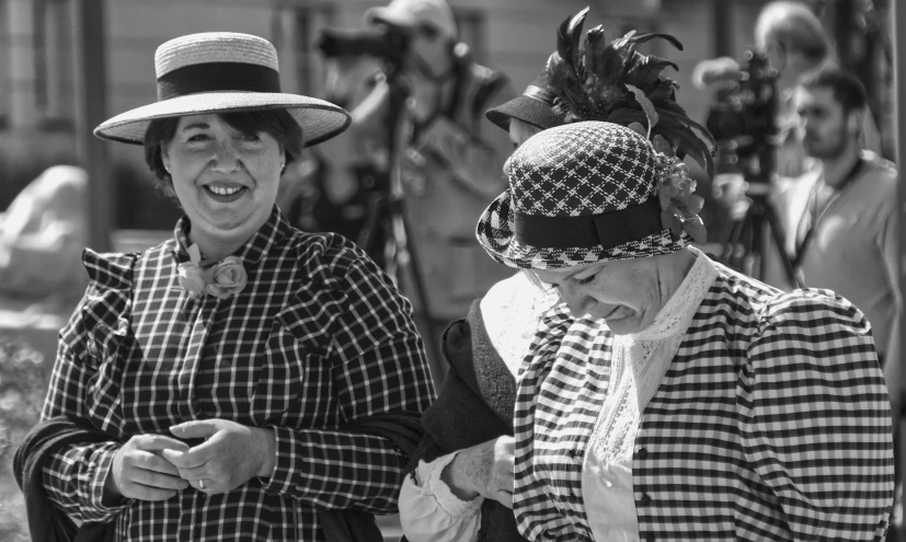 two ladies wearing hats looking at their cell phones