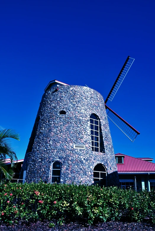 a big stone windmill in front of a home