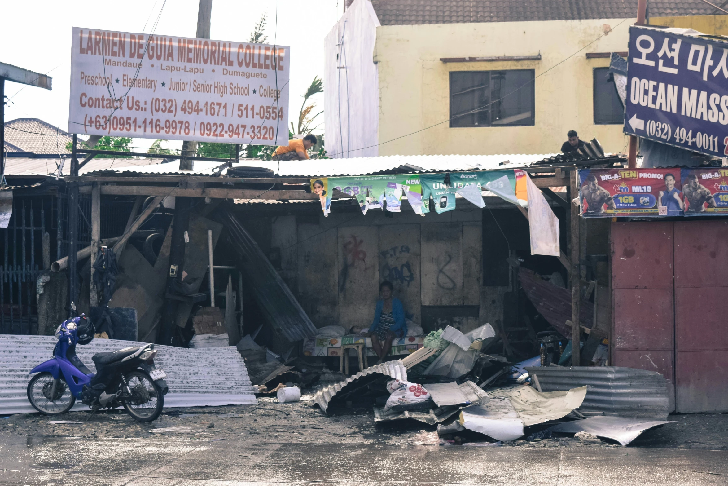 a person riding on a motorcycle next to a pile of rubble