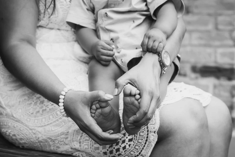 a woman holding the feet of a baby