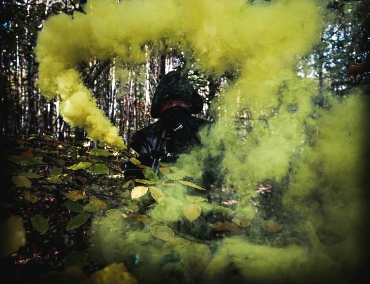 a man in a black jacket is blowing yellow smoke