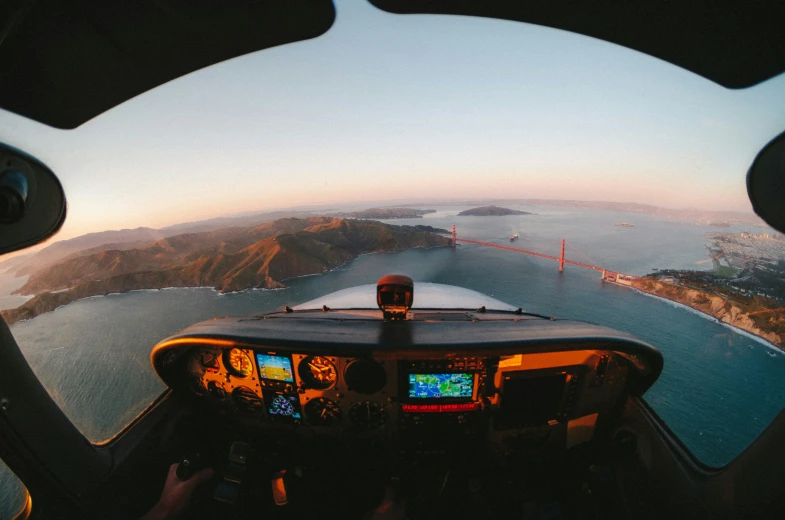 view from inside a helicopter over the bay and a bridge