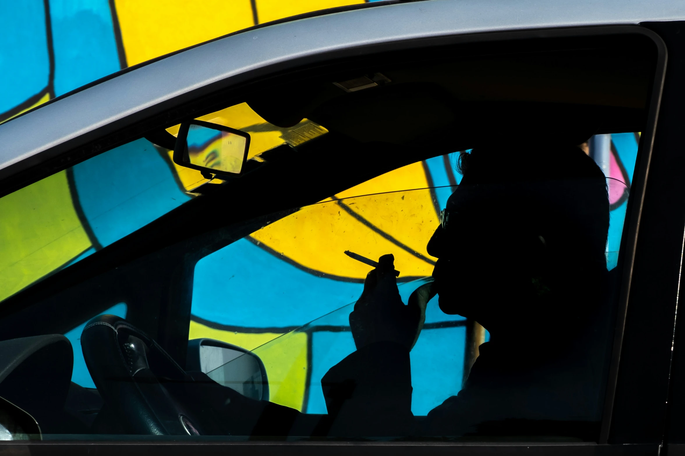 a person sits inside of a parked vehicle