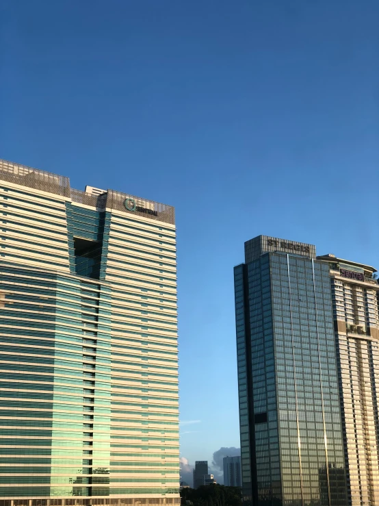 two very large buildings in front of a blue sky