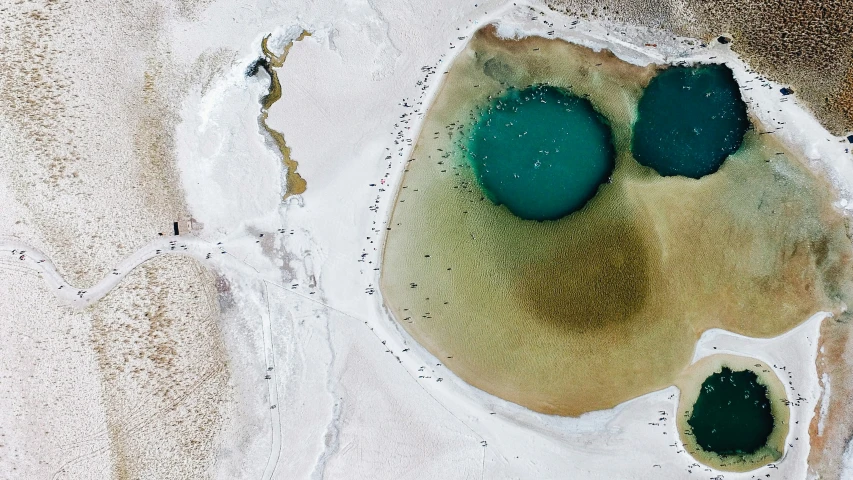 three blue balls sit in the sand near the ocean