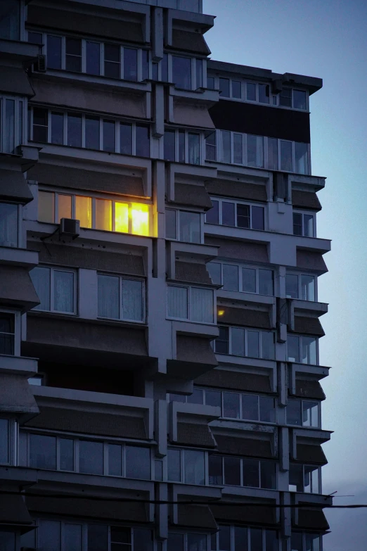 a very tall building with windows lit up by yellow light