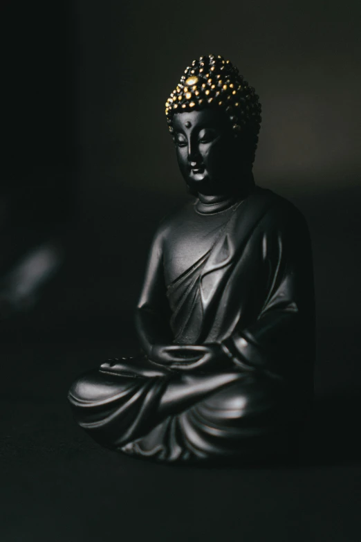 a buddha statue sitting in the dark alone