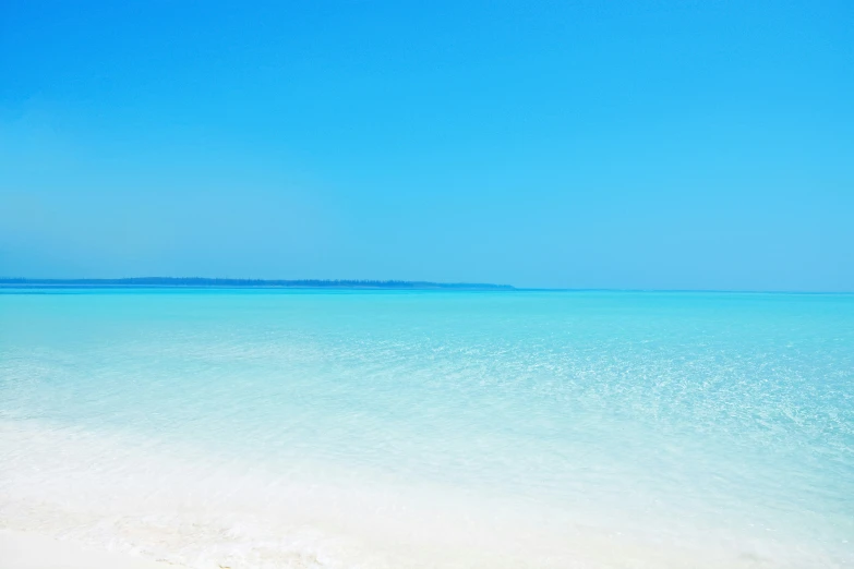 a beach that has some people walking in it