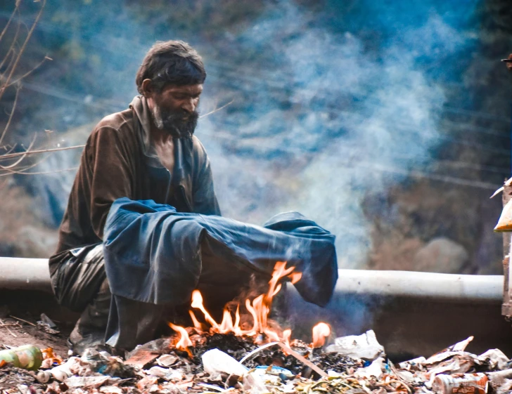 a man sitting in front of a fire