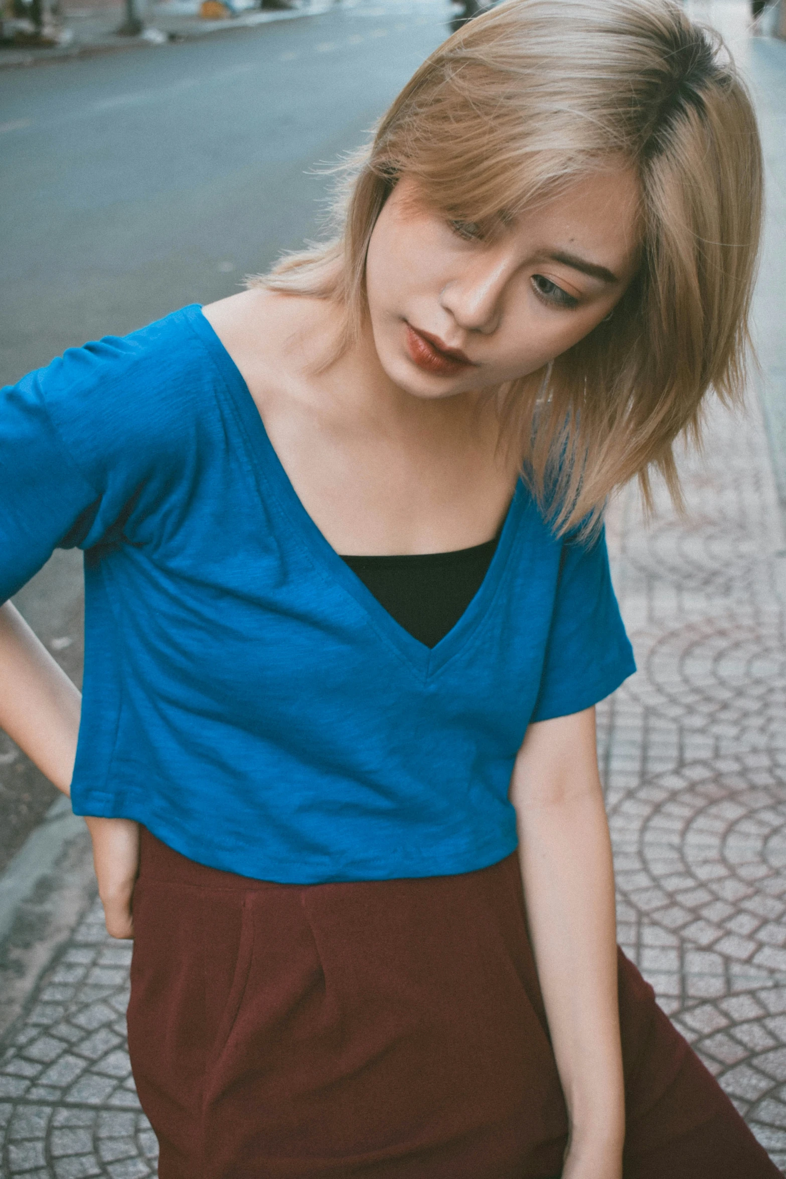 a young woman in blue shirt walking down the street