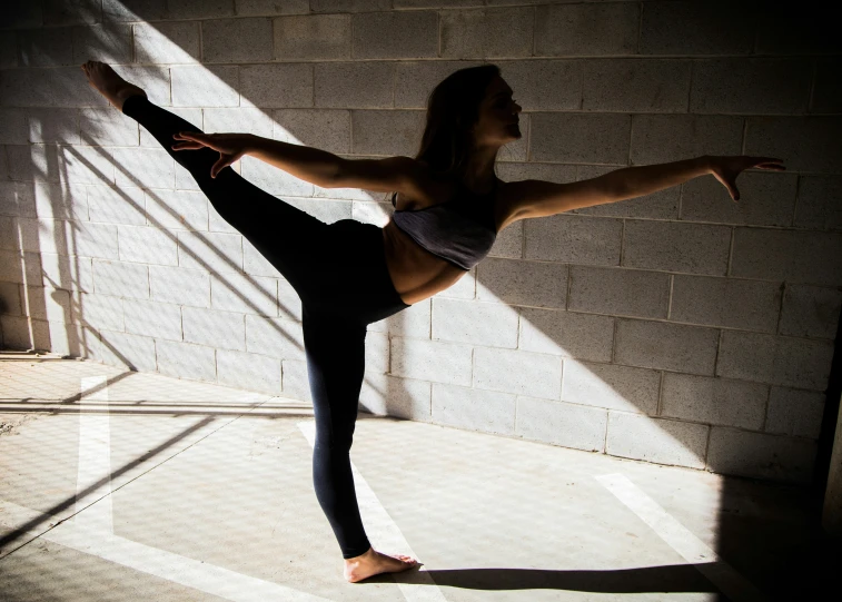 a female dancer stands in a stretching position
