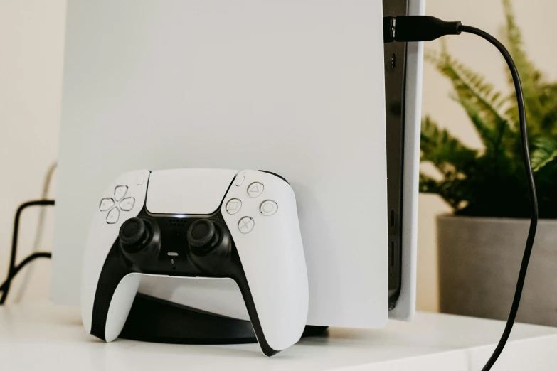 two video game controllers sitting next to a white wall