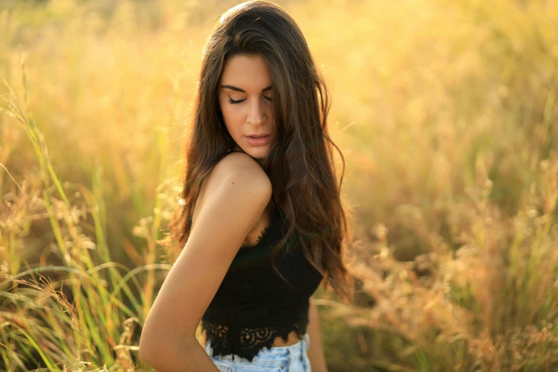 a young woman in an open field of tall grass