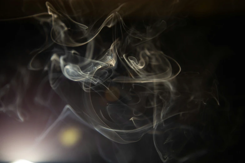 smoke rises up against the dark background of this image